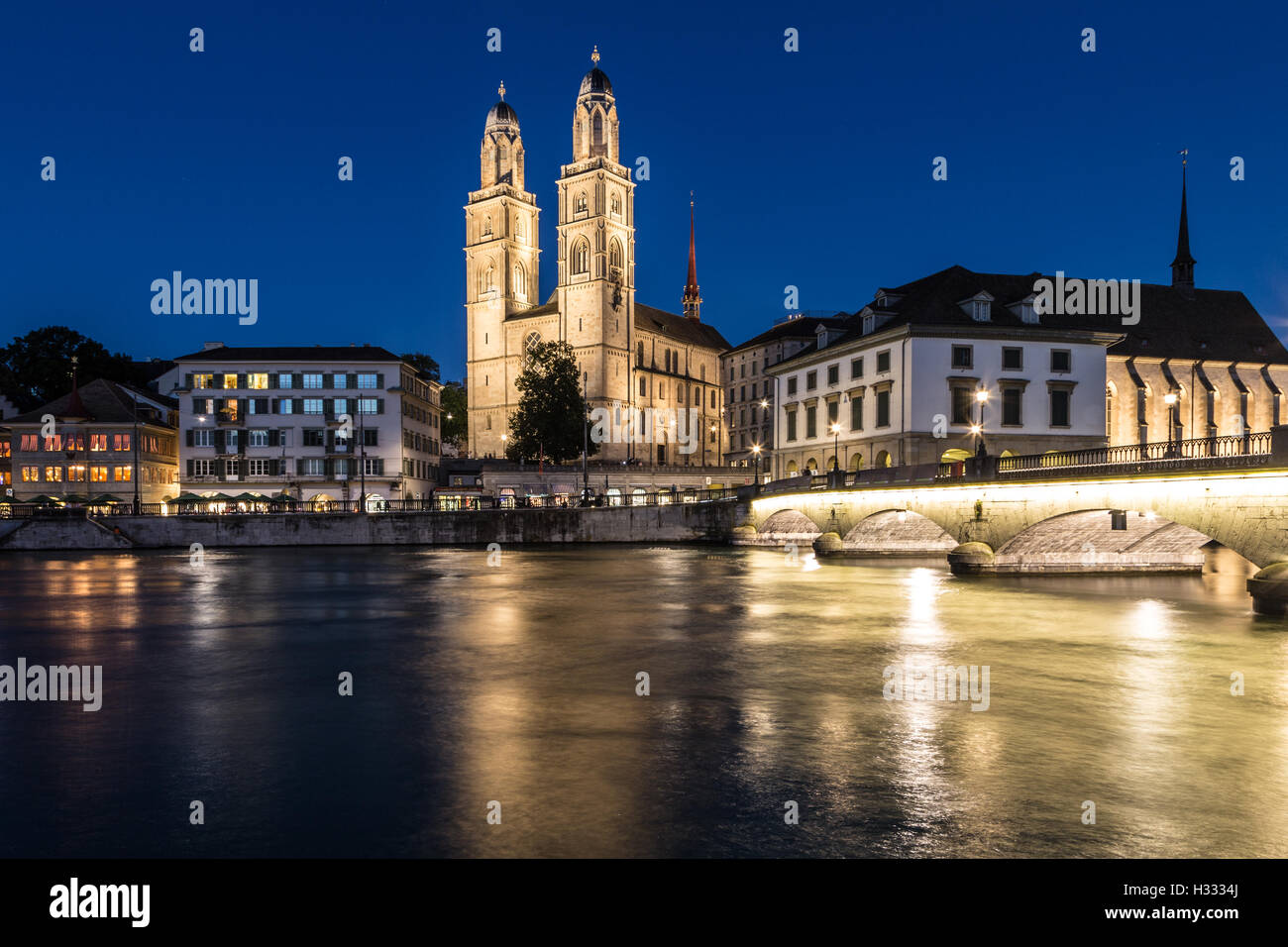 Nachtansicht der Zürich-Kathedrale (Grossmünster) mit seinen Lichtern, Nachdenken über die Limmat in Zürich larges Stockfoto