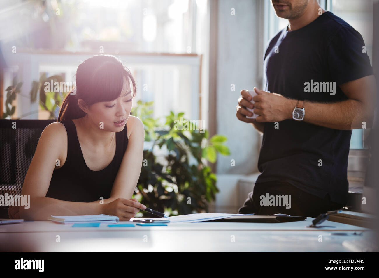 Aufnahme von zwei jungen Geschäftspartnern neue Ideen im Büro zu diskutieren. Junge Menschen arbeiten gemeinsam an neuen Business-Projekt. Stockfoto