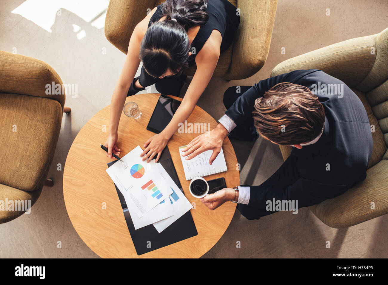 Draufsicht der junge Geschäftsmann und Frau sitzend im Büro Lobby in Diagrammen arbeiten. Corporate Menschen diskutieren neue bu Stockfoto