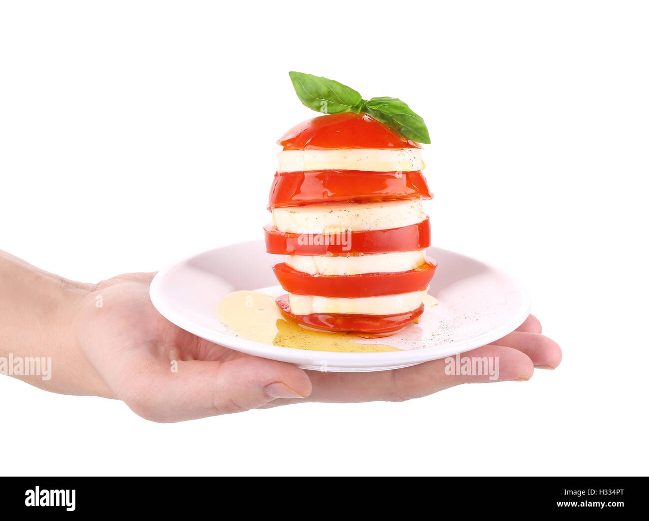 Caprese-Salat auf Teller in der Hand. Stockfoto