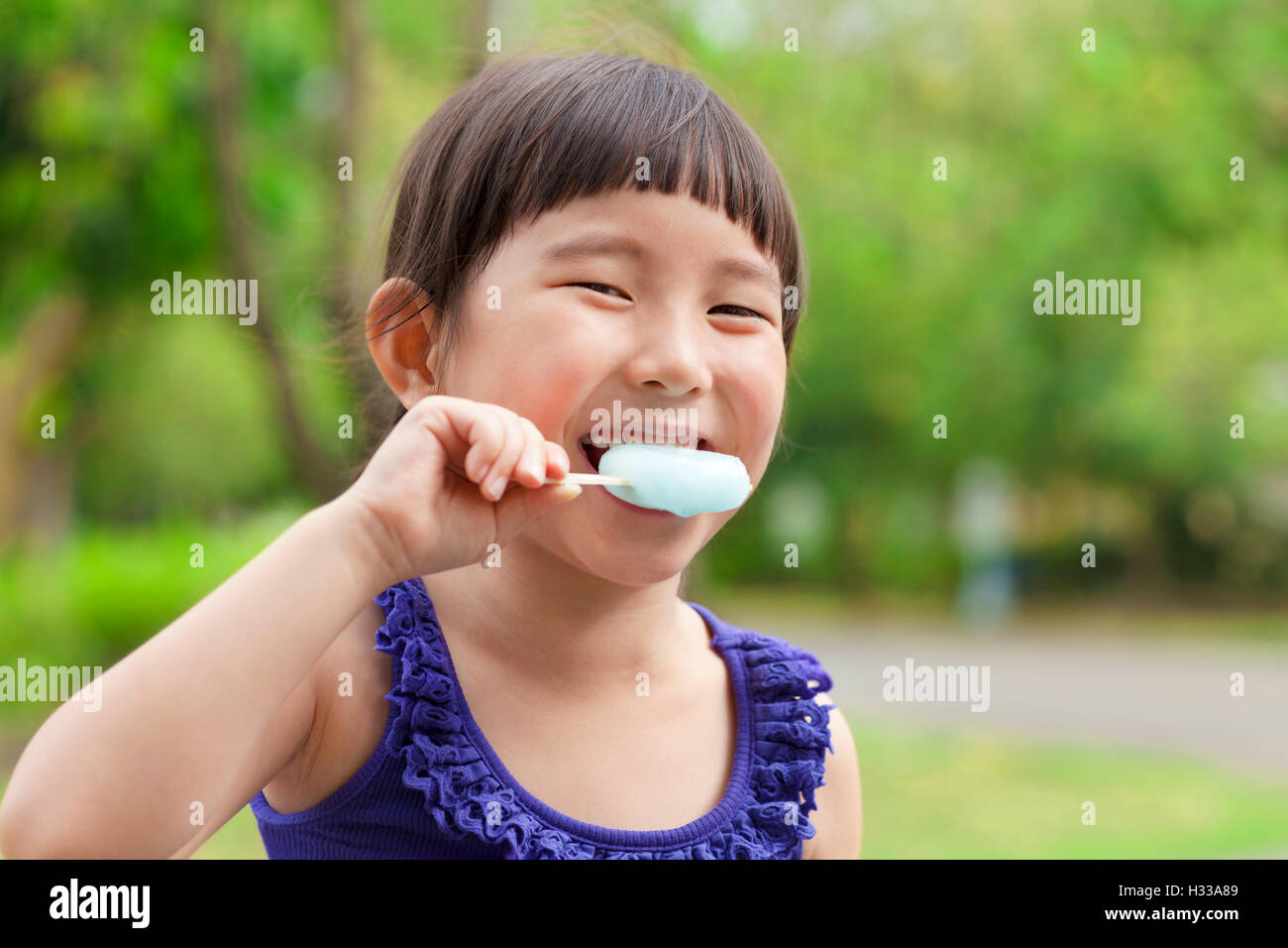 glückliche kleine Mädchen essen Eis am Stiel im Sommer Stockfoto
