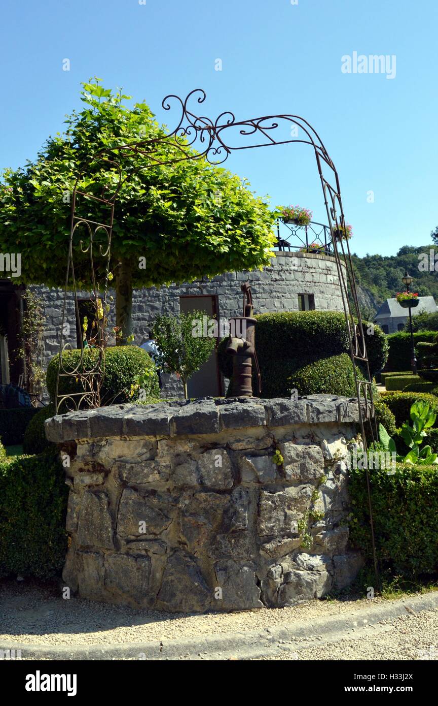 Ehemalige gut in Steinen mit einer alten Pumpe mit Hand. Stockfoto