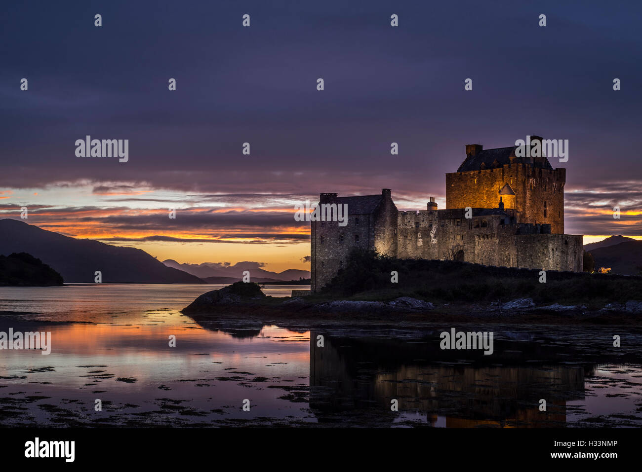 Beleuchtete Eilean Donan Castle bei Sonnenuntergang im Loch Duich, Ross und Cromarty, Western Highlands von Schottland, Großbritannien Stockfoto