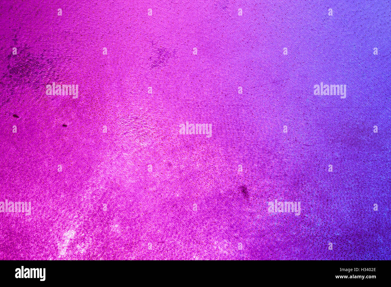 Details der Hautstruktur von einem Tamburin, von blau und rosa Lichter von hinten beleuchtet. Stockfoto