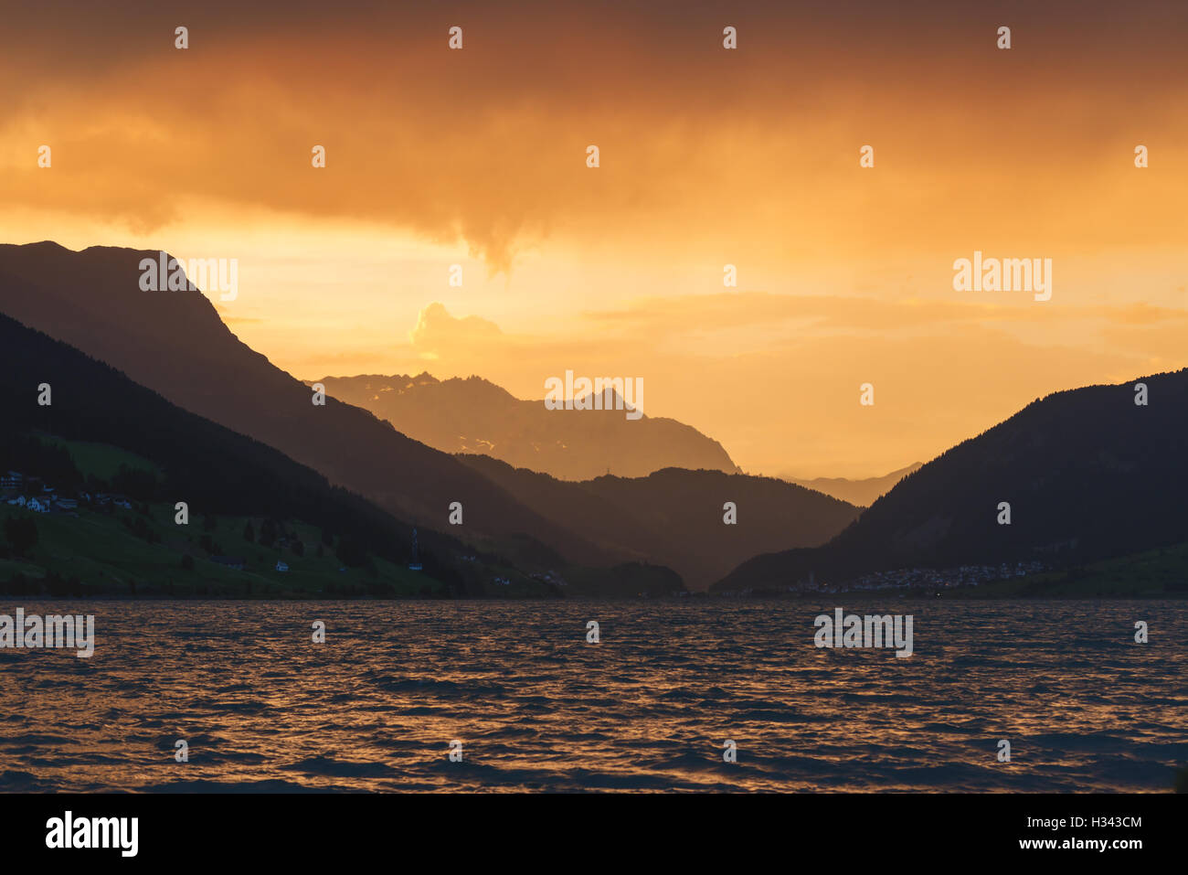 Schöne Aussicht auf den See Resia. Dramatischer Himmel und farbenprächtigen Sonnenuntergang. Alpen, Italien, Europa. Stockfoto