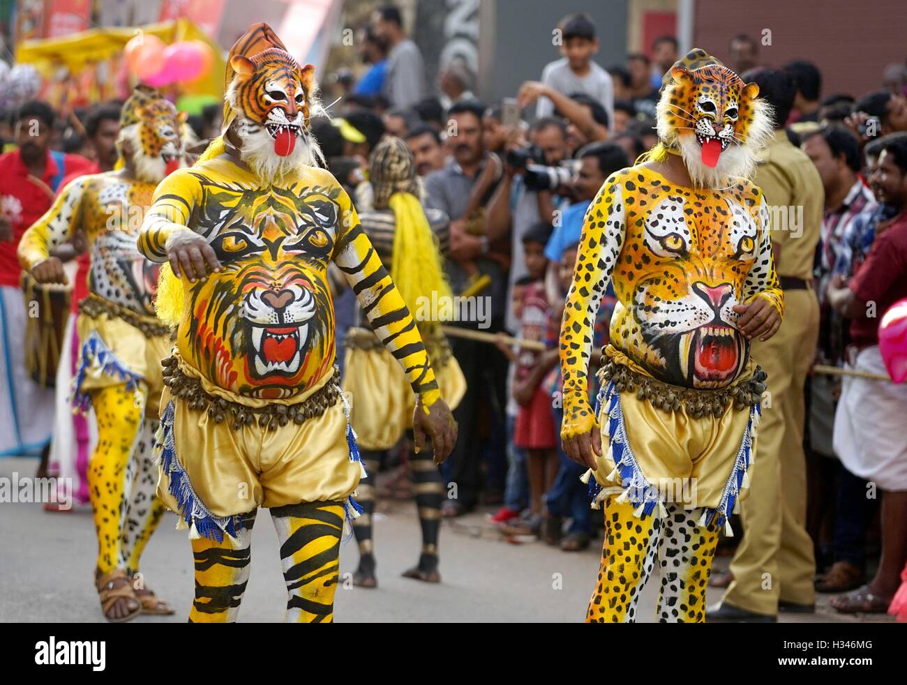 Ausgebildete Tänzer mit ihren sorgfältig lackierten Karosserien Deckmantel der Tiger führen die berühmten Pulikali die Straßen von Thrissur, Kerala Stockfoto