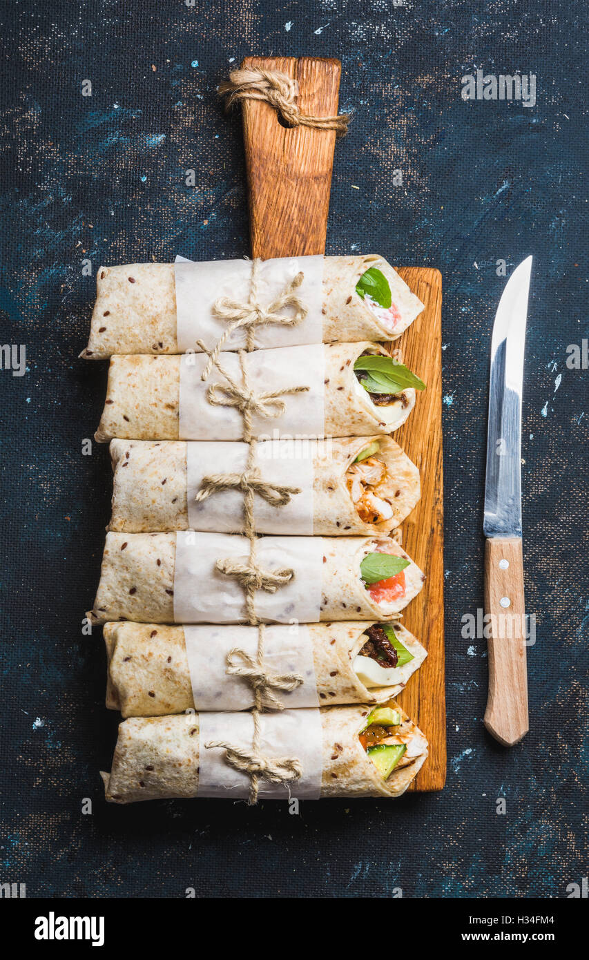 Tortilla wraps mit verschiedenen Füllungen auf grauem Beton dunkel ...