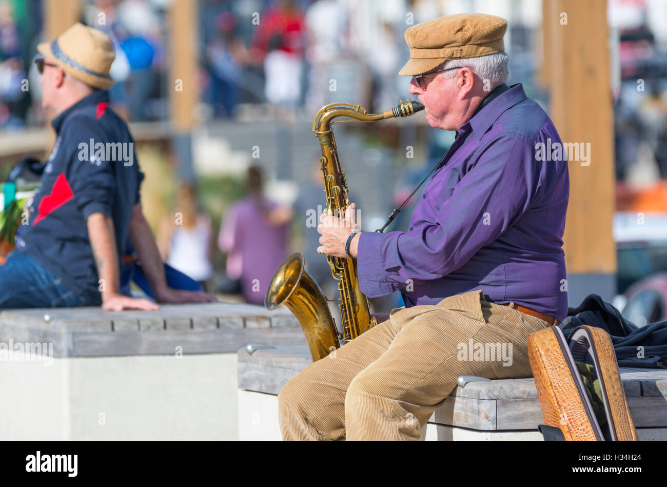Busker setzte sich das Saxophon zu spielen. Stockfoto