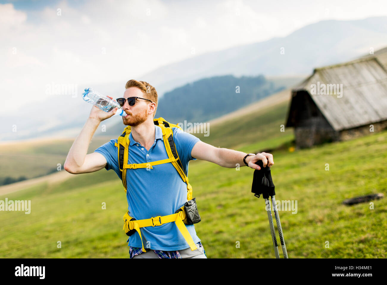 Junge Wanderer gestoppt und trinken Wasser aus einer Flasche Stockfoto