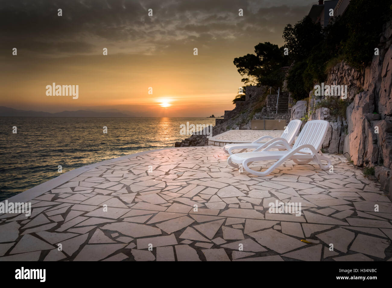 Zwei Sonnenliegen auf der Terrasse am Sonnenaufgang oder am Morgen an der Adria in Trpanj Kroatien Stockfoto