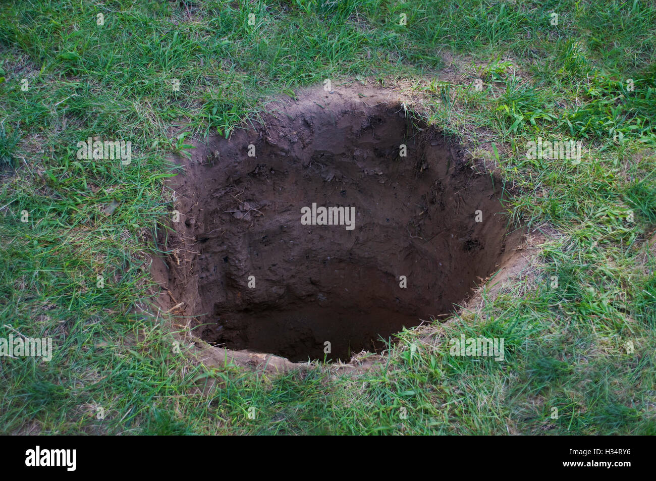 Tiefen Schmutz Loch im Boden oder Rasen Stockfoto