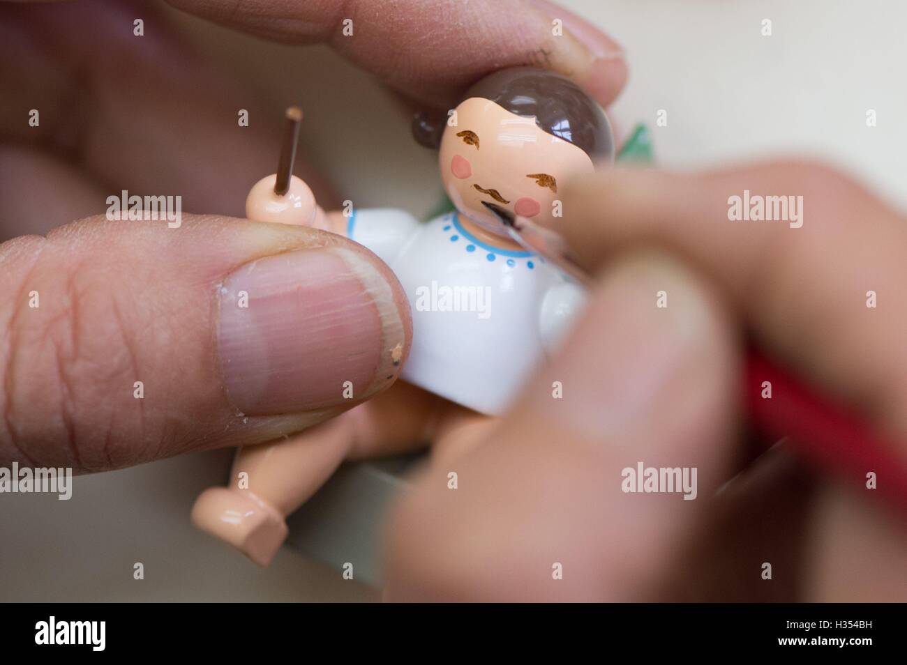 Nhainichen, Deutschland. 20. Sep, 2016. Abbildung Maler malt eine Engelsfigur in den Räumlichkeiten des Familienunternehmens Wendt & Kuehn in nhainichen, Deutschland, 20. September 2016. Das deutsche Unternehmen stellt handgefertigte kleine hölzerne Kunstwerke seit 1915 her. Seit 2014 wurden Figuren, hergestellt von der Firma auf dem Display in verschiedenen Städten wie St. Petersburg, Moskau und Shanghai im Rahmen einer Welttournee "Handmade in Germany." Die nächste Station wird Peking, China, vom 21. bis 30. Oktober 2016 sein. Foto: Sebastian Kahnert/Dpa/Alamy Live News Stockfoto