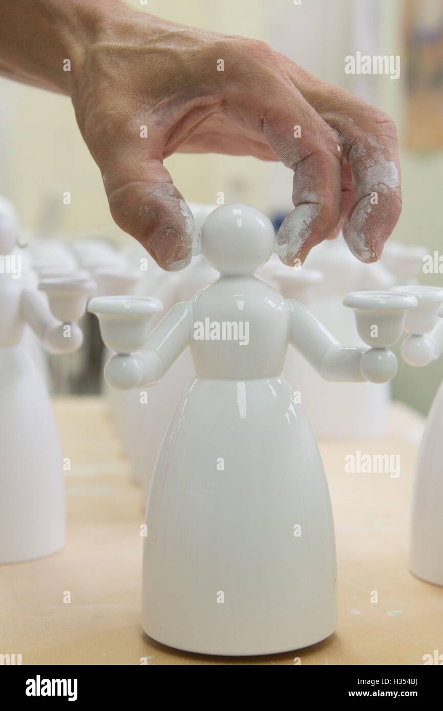 Nhainichen, Deutschland. 20. Sep, 2016. Gilbert Haenel setzt einen gemalten "Licht Engel" auf einem Tisch in den Räumlichkeiten des Familienunternehmens Wendt & Kuehn in nhainichen, Deutschland, 20. September 2016. Das deutsche Unternehmen stellt handgefertigte kleine hölzerne Kunstwerke seit 1915 her. Seit 2014 wurden Figuren, hergestellt von der Firma auf dem Display in verschiedenen Städten wie St. Petersburg, Moskau und Shanghai im Rahmen einer Welttournee "Handmade in Germany." Die nächste Station wird Peking, China, vom 21. bis 30. Oktober 2016 sein. Foto: Sebastian Kahnert/Dpa/Alamy Live News Stockfoto