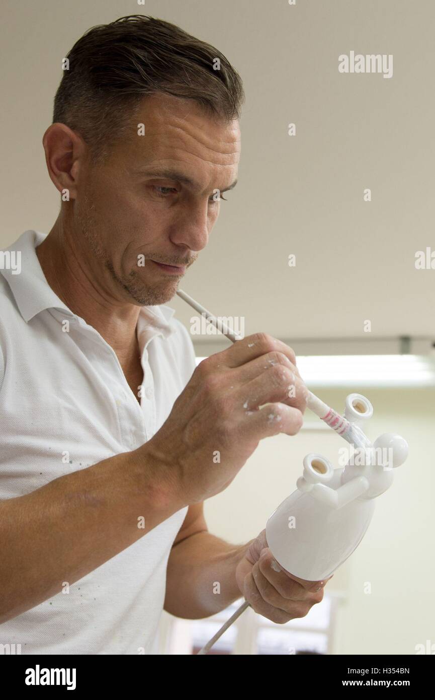 Nhainichen, Deutschland. 20. Sep, 2016. Gilbert Haenel malt "Licht Engel" in den Räumlichkeiten des Familienunternehmens Wendt & Kuehn in nhainichen, Deutschland, 20. September 2016. Das deutsche Unternehmen stellt handgefertigte kleine hölzerne Kunstwerke seit 1915 her. Seit 2014 wurden Figuren, hergestellt von der Firma auf dem Display in verschiedenen Städten wie St. Petersburg, Moskau und Shanghai im Rahmen einer Welttournee "Handmade in Germany." Die nächste Station wird Peking, China, vom 21. bis 30. Oktober 2016 sein. Foto: Sebastian Kahnert/Dpa/Alamy Live News Stockfoto