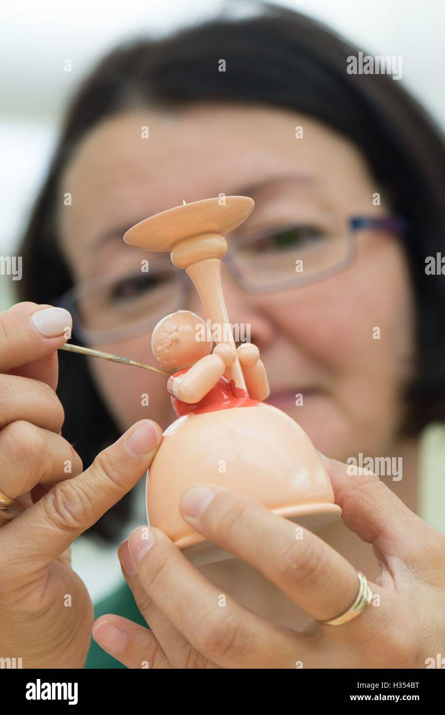 Figurenmaler Petra Wilde malt eine Engelsfigur, die eine Kerze in den Räumlichkeiten des Familienunternehmens Wendt & Kuehn in nhainichen, Deutschland, 20. September 2016 enthält. Das deutsche Unternehmen stellt handgefertigte kleine hölzerne Kunstwerke seit 1915 her. Seit 2014 wurden Figuren, hergestellt von der Firma auf dem Display in verschiedenen Städten wie St. Petersburg, Moskau und Shanghai im Rahmen einer Welttournee "Handmade in Germany." Die nächste Station wird Peking, China, vom 21. bis 30. Oktober 2016 sein. Foto: Sebastian Kahnert/dpa Stockfoto