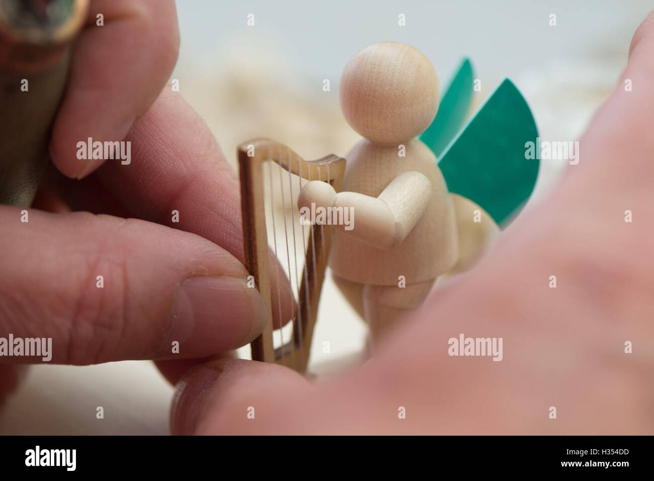 Nhainichen, Deutschland. 20. Sep, 2016. Ein Mitarbeiter legt eine Harfe auf eine Engelsfigur in den Räumlichkeiten des Familienunternehmens Wendt & Kuehn in nhainichen, Deutschland, 20. September 2016. Das deutsche Unternehmen stellt handgefertigte kleine hölzerne Kunstwerke seit 1915 her. Seit 2014 wurden Figuren, hergestellt von der Firma auf dem Display in verschiedenen Städten wie St. Petersburg, Moskau und Shanghai im Rahmen einer Welttournee "Handmade in Germany." Die nächste Station wird Peking, China, vom 21. bis 30. Oktober 2016 sein. Foto: Sebastian Kahnert/Dpa/Alamy Live News Stockfoto