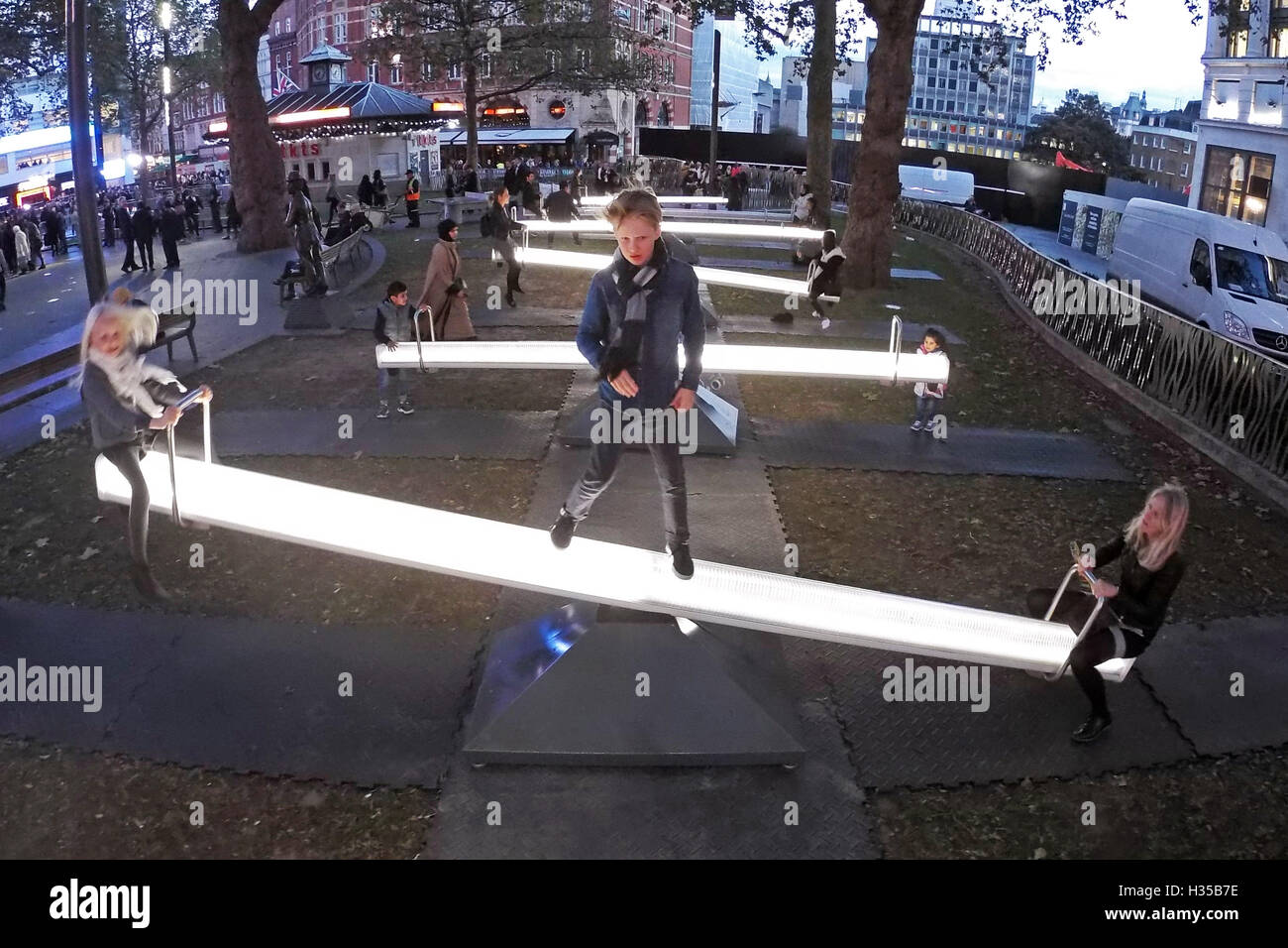 London, UK. 5. Oktober 2016. Menschen spielen auf Impuls, ein Meer von Gesang Wippen Kunstinstallation in Leicester Square Gardens in London. Die 15 Wippen sind ausgestattet mit LED Beleuchtung, Beleuchtung und Lautsprecher, die durch Bewegung aktiviert und aktivieren, wenn die Leute die Wippen. Bildnachweis: Paul Brown/Alamy Live-Nachrichten Stockfoto