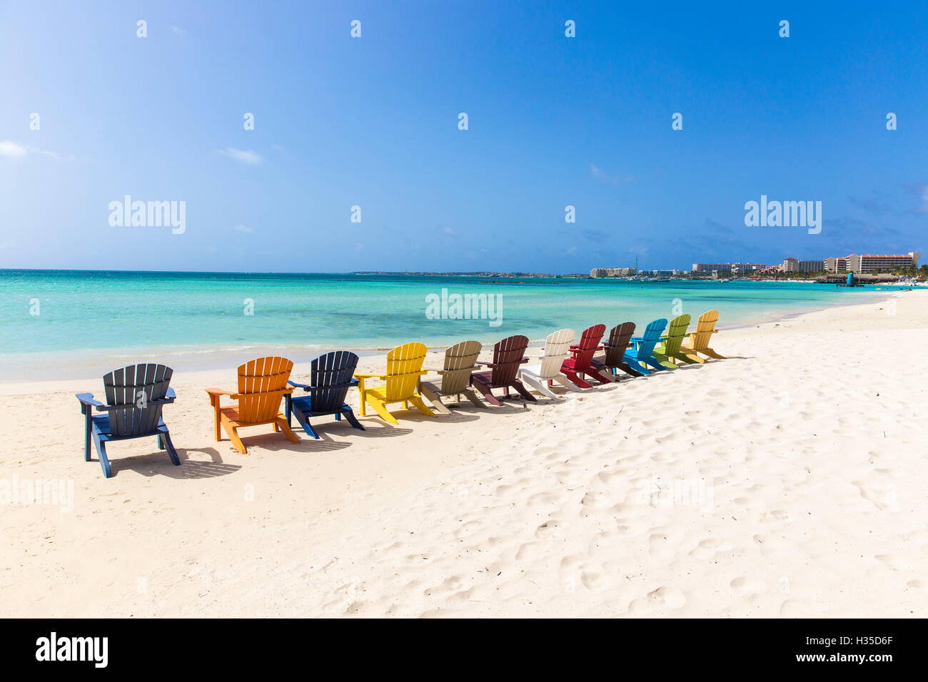 Eine Reihe von bunten hölzernen Liegestühle auf Palm Beach, Aruba, Niederländische Antillen, Karibik Stockfoto
