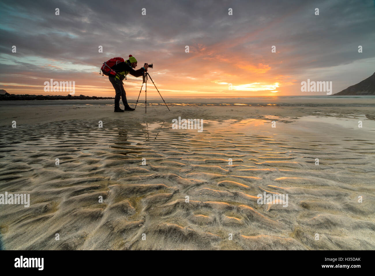Mitternachtssonne rahmt Fotograf in Aktion am Skagsanden Strand, Ramberg, Nordland Grafschaft, Lofoten-Inseln, Arktis, Norwegen Stockfoto
