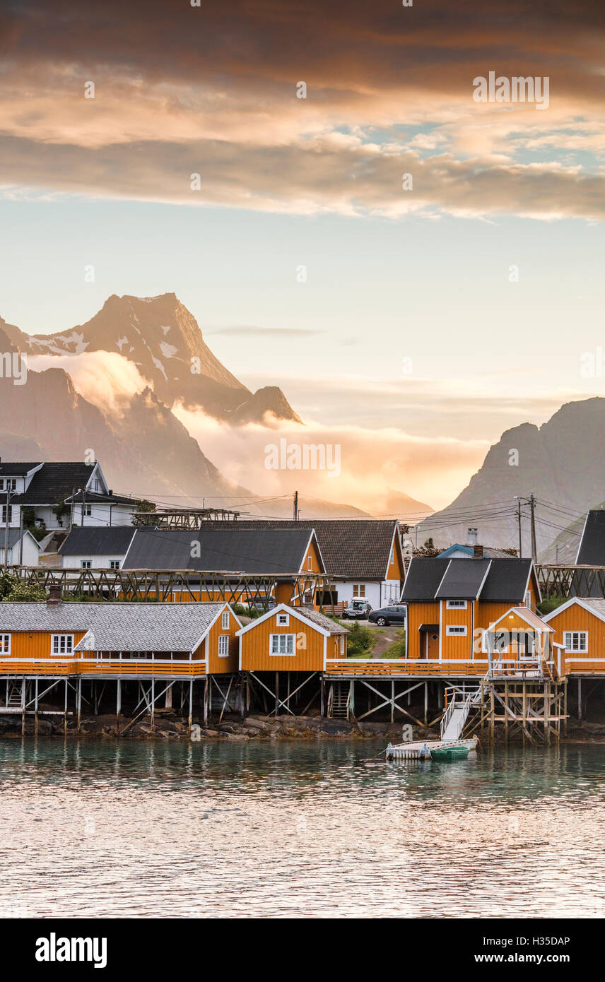 Sonnenuntergang auf dem Fischerdorf umrahmt von felsigen Gipfeln und Meer, Sakrisoya, Nordland Grafschaft, Lofoten-Inseln, Arktis, Norwegen Stockfoto