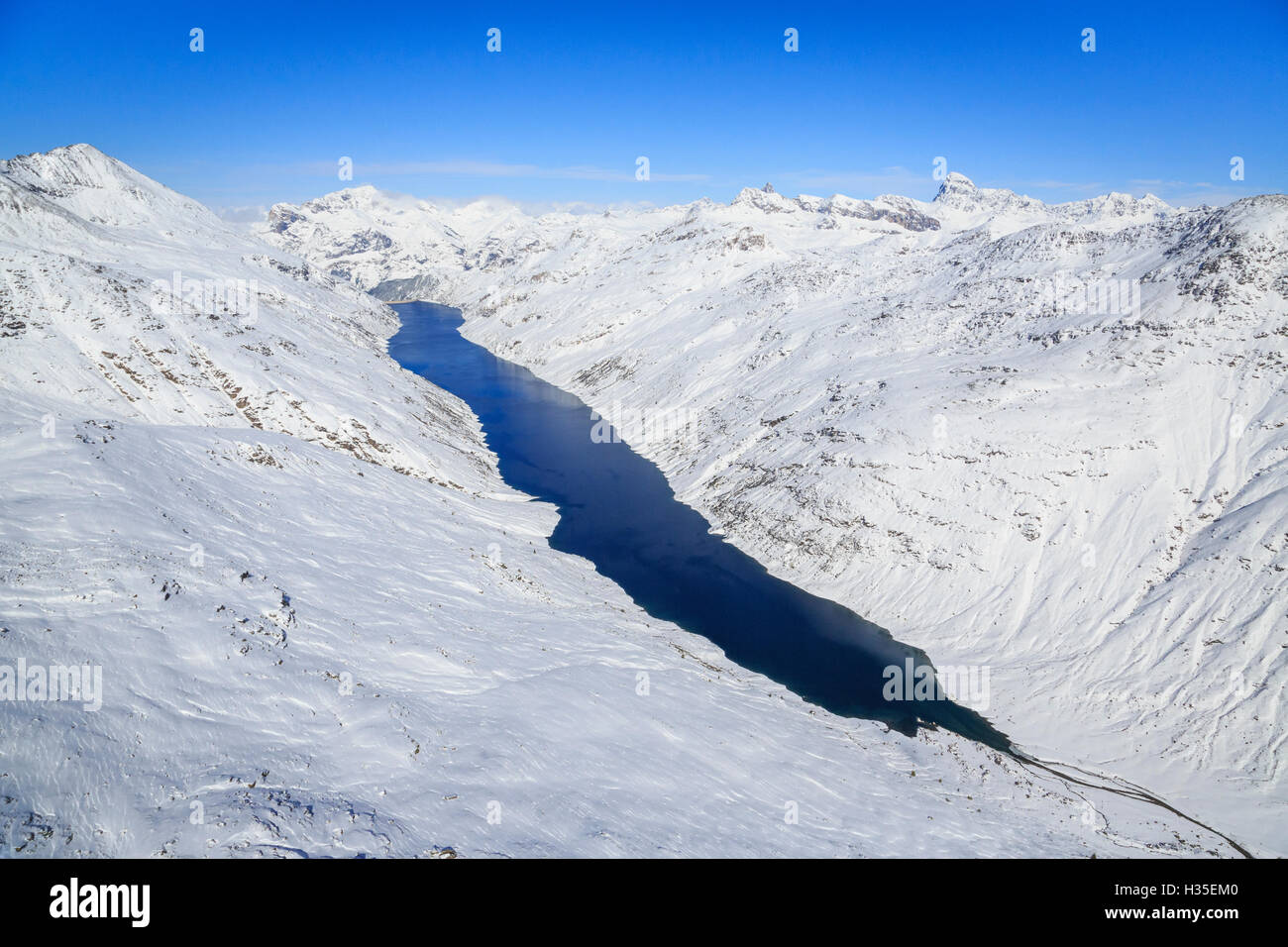 Luftaufnahme des alpinen Lago di Lei, umgeben von Schnee, Val di Lei, Chiavenna, Spluga Tal, Valtellina, Lombardei, Italien Stockfoto