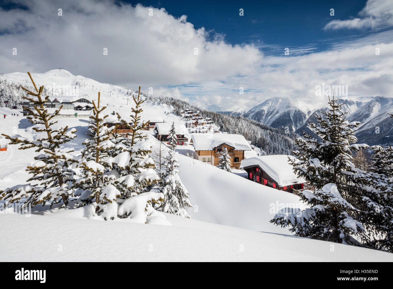 Die Wintersonne scheint auf die verschneiten Berge Hütten und Wälder, Bettmeralp, Bezirk von Raron, Kanton Wallis, Schweiz Stockfoto