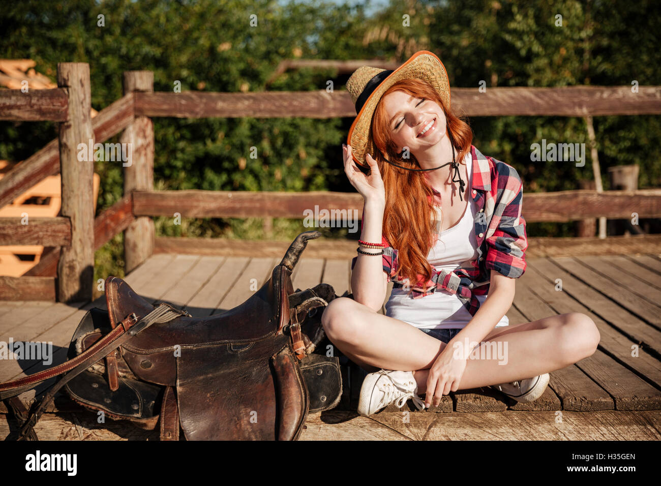 Porträt der lächelnde junge Frau Cowgirl Hut und kariertes Hemd Stockfoto