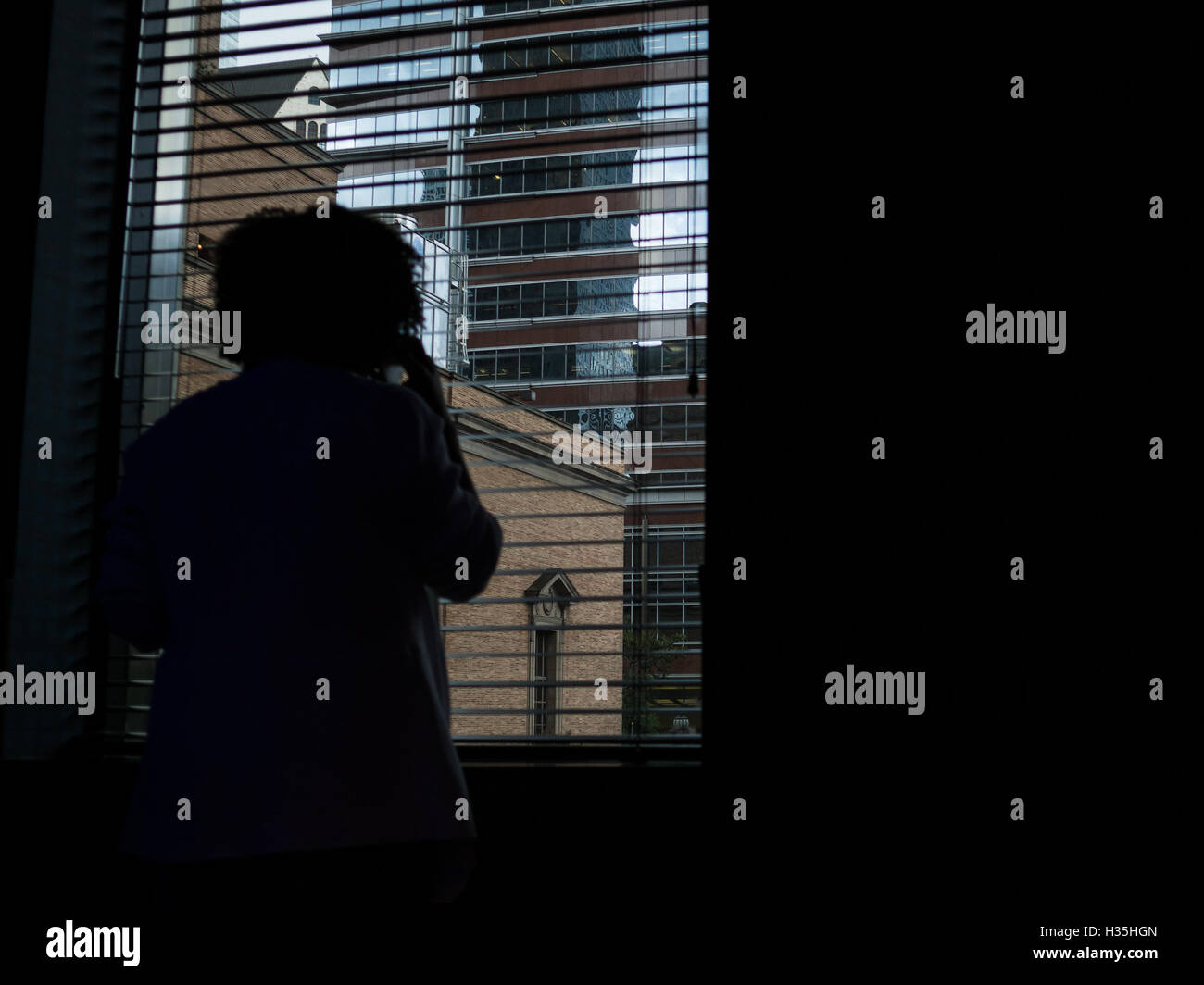 Frau an einem Fenster der Innenstadt von Los Angeles USA Stockfoto
