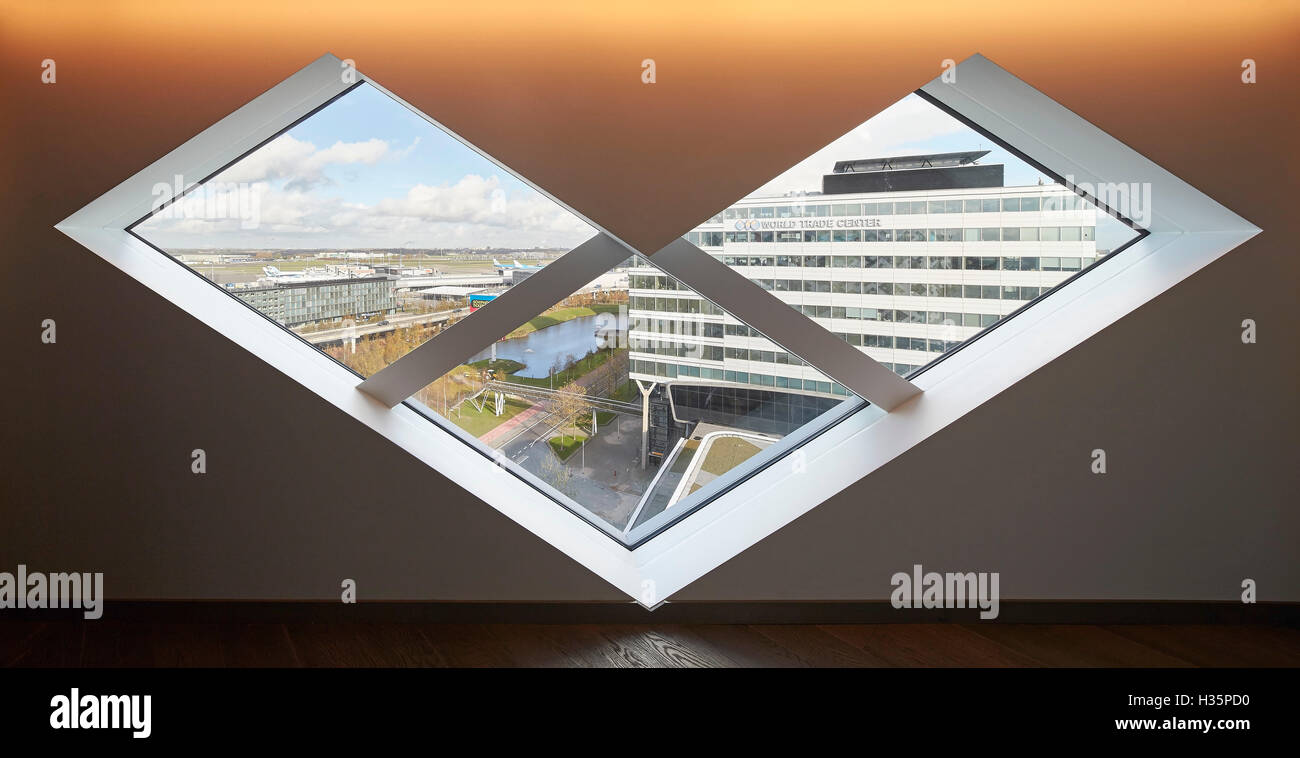 Blick durch rautenförmige Fenster. Hilton Amsterdam Airport Schiphol, Amsterdam, Niederlande. Architekt: Mecanoo Architects, 2015. Stockfoto