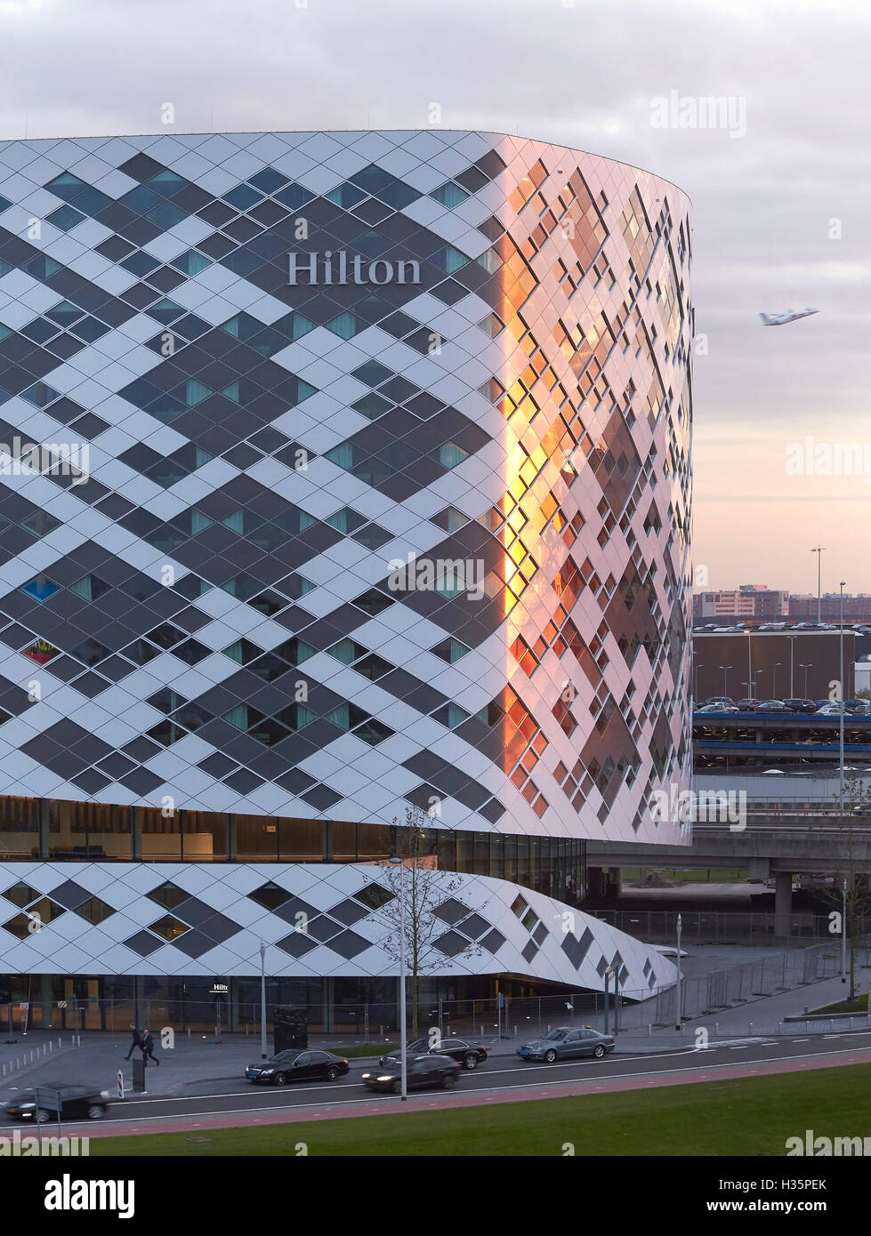 Diamant gemusterten Fassade im Abendlicht. Hilton Amsterdam Airport Schiphol, Amsterdam, Niederlande. Architekt: Mecanoo Architects, 2015. Stockfoto