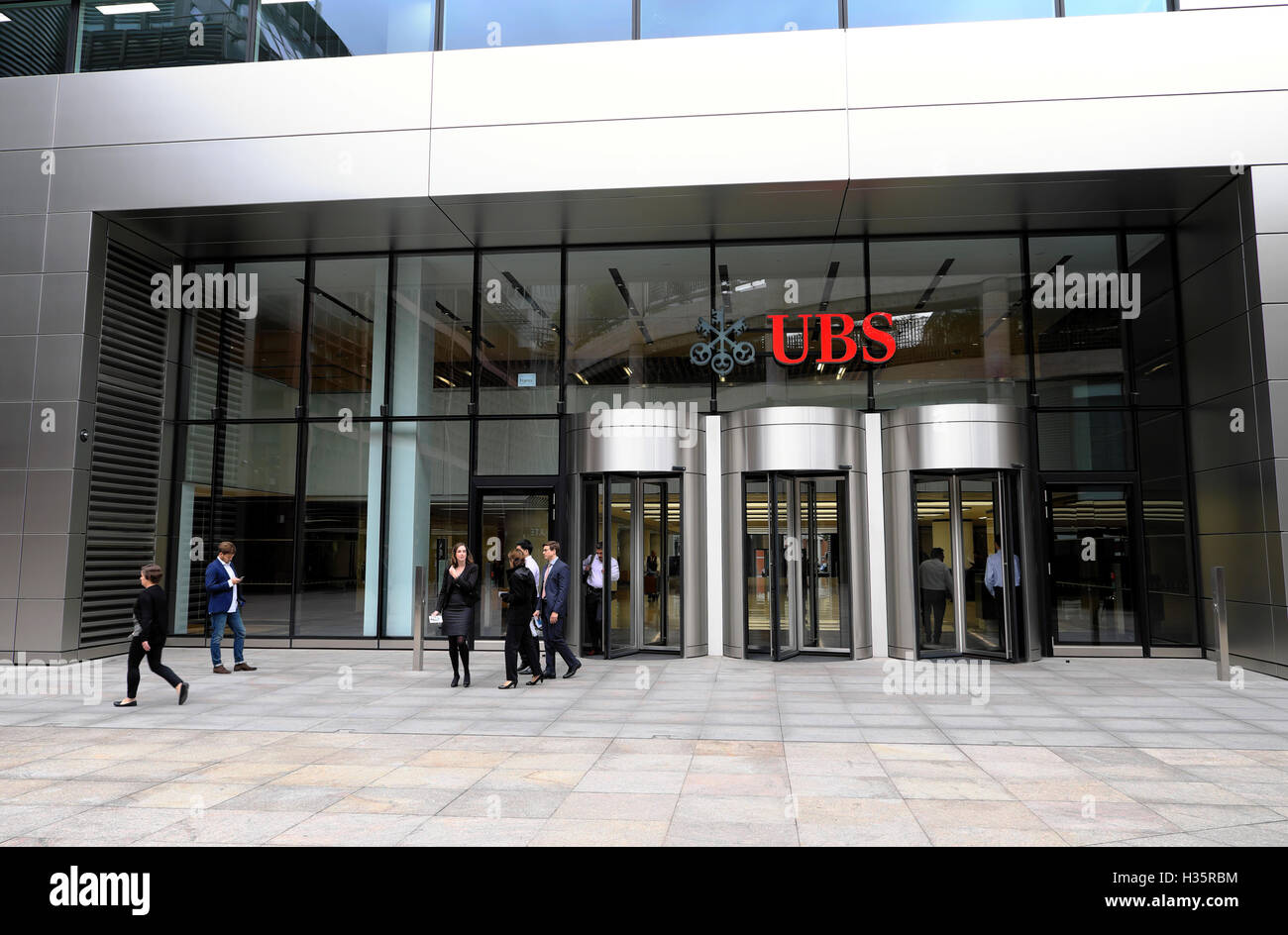 Mitarbeiter außerhalb des Hauptsitzes des 5 Broadgate UBS Gebäudes unterzeichnen zur Mittagszeit die Investmentbank für Finanzdienstleistungen in der Londoner City, UK, KATHY DEWITT Stockfoto