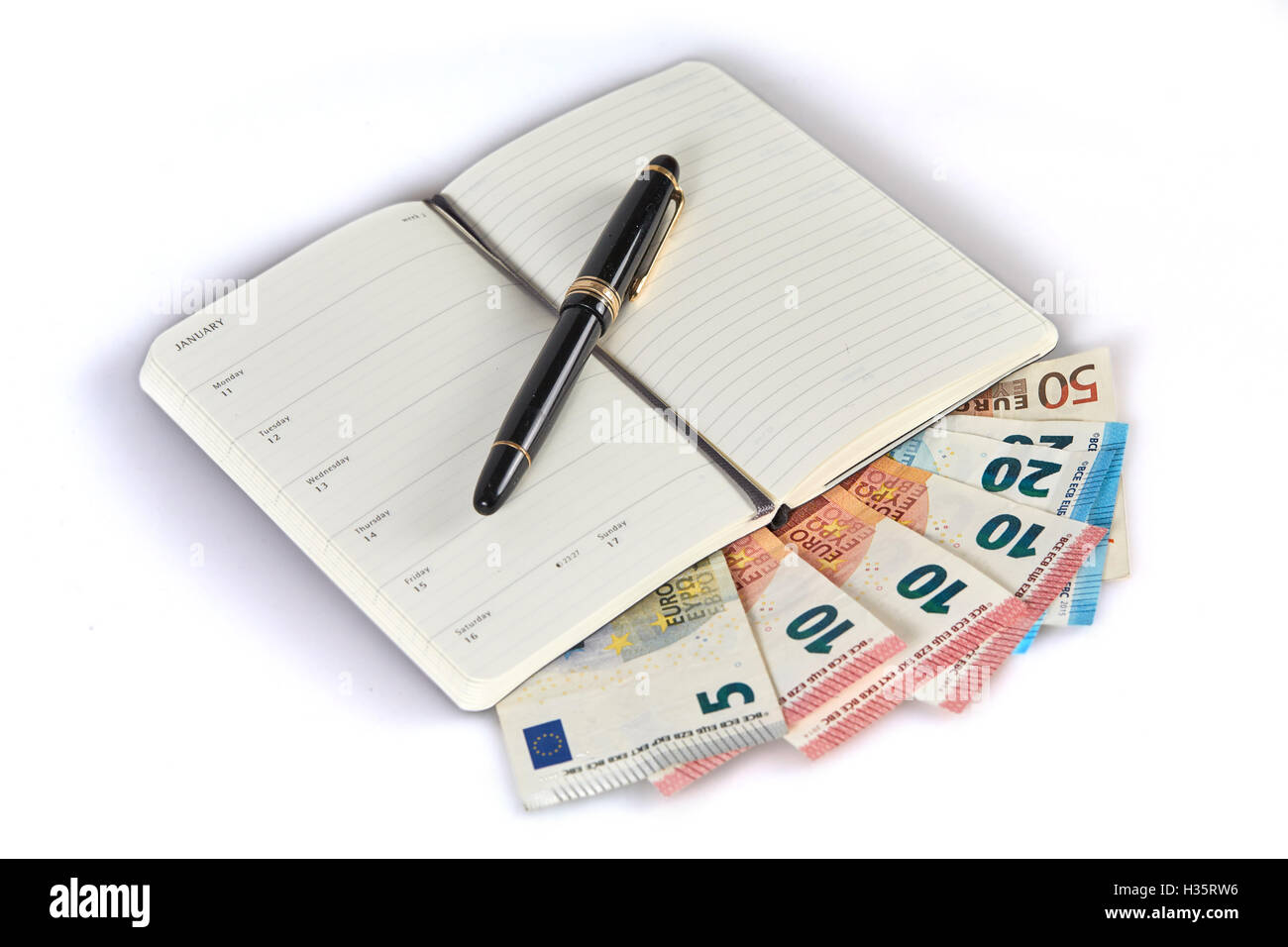 Geld verdienen mit dem Schreiben auf Geld Banknoten symbolisierten mit Stift und Notizbuch Stockfoto