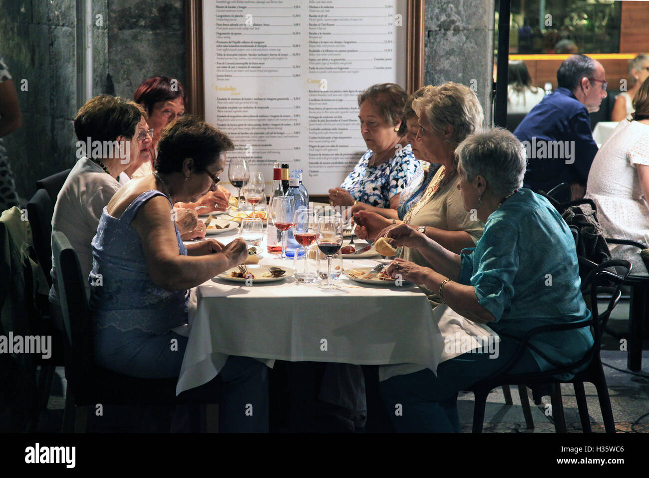 Spanische Frau, die abends im Freien in einem Restaurant in Bilbao, Spanien, zu Abend gegessen hat Stockfoto