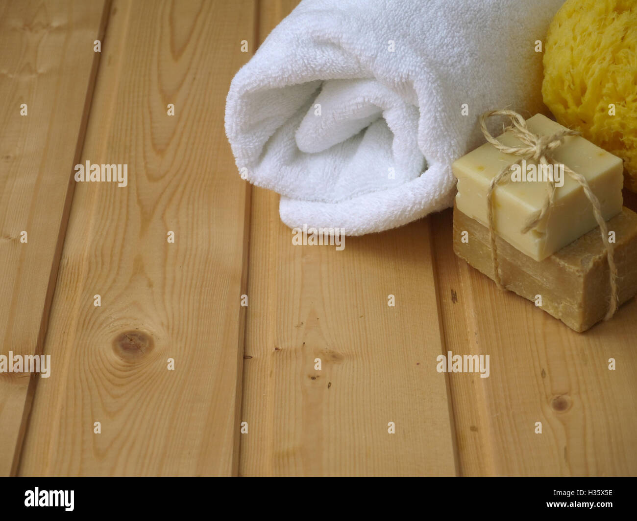 Handtuch, Seife und Schwamm auf dem hölzernen Hintergrund Stockfoto