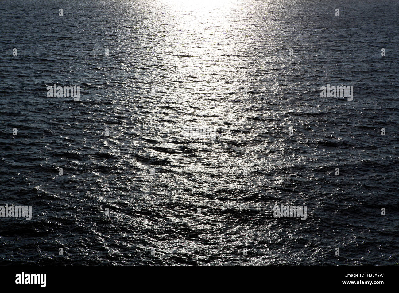 Die Sonne spiegelt das sanft plätschernden Meer schaffen helle Highlights an der Küste von UK. Stockfoto