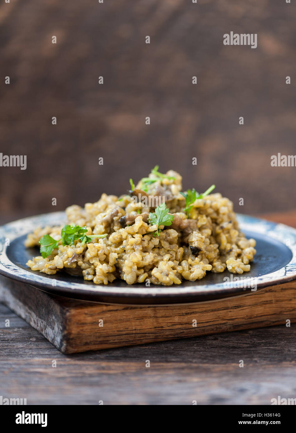 Pilz-Risotto mit brauner Reis, Petersilie und Kurkuma Stockfoto