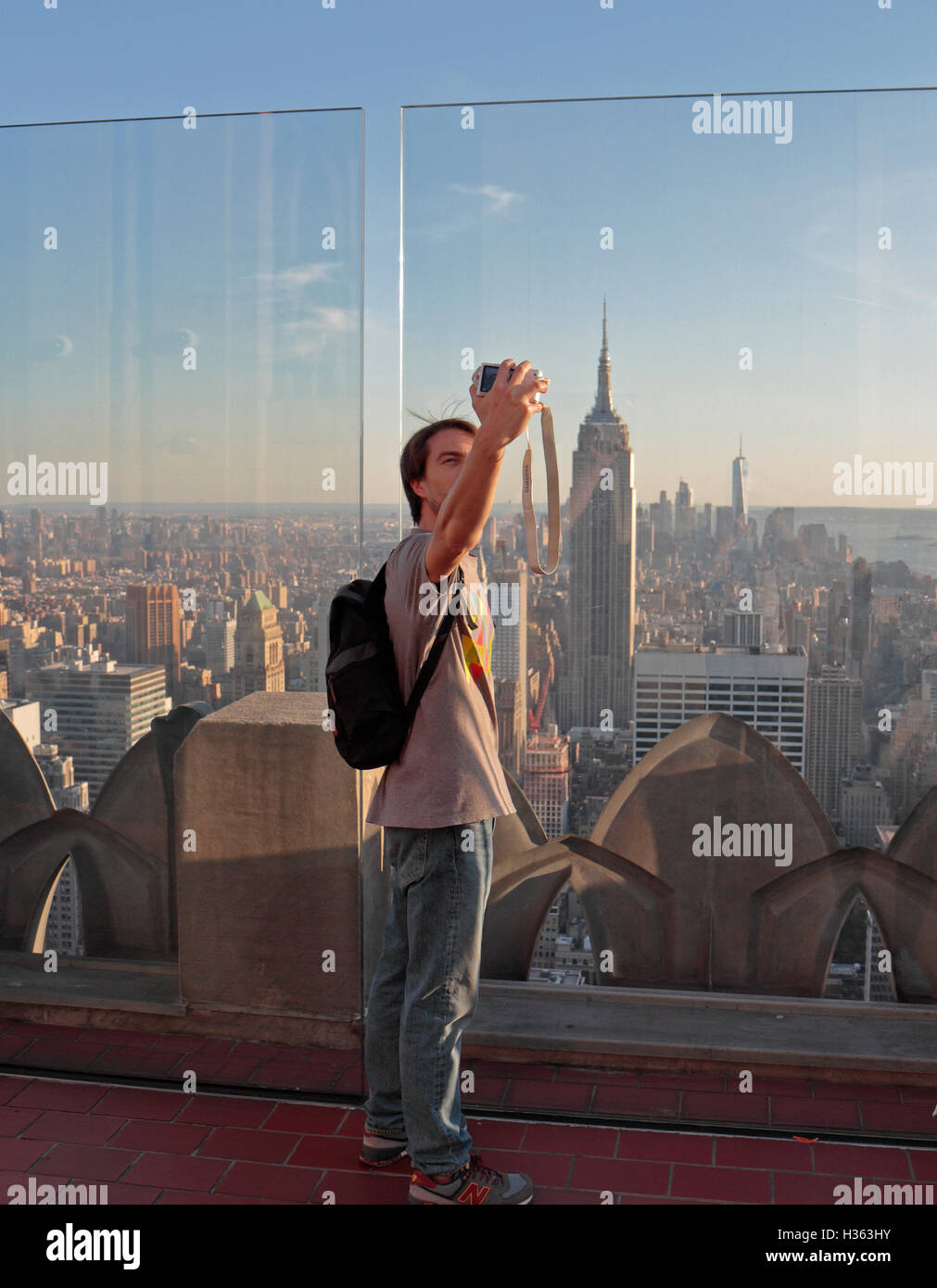 Ein Mann, ein Selbstporträt mit dem Empire State Building hinter von "Top of the Rock", Manhattan, New York City, Vereinigte Staaten. Stockfoto