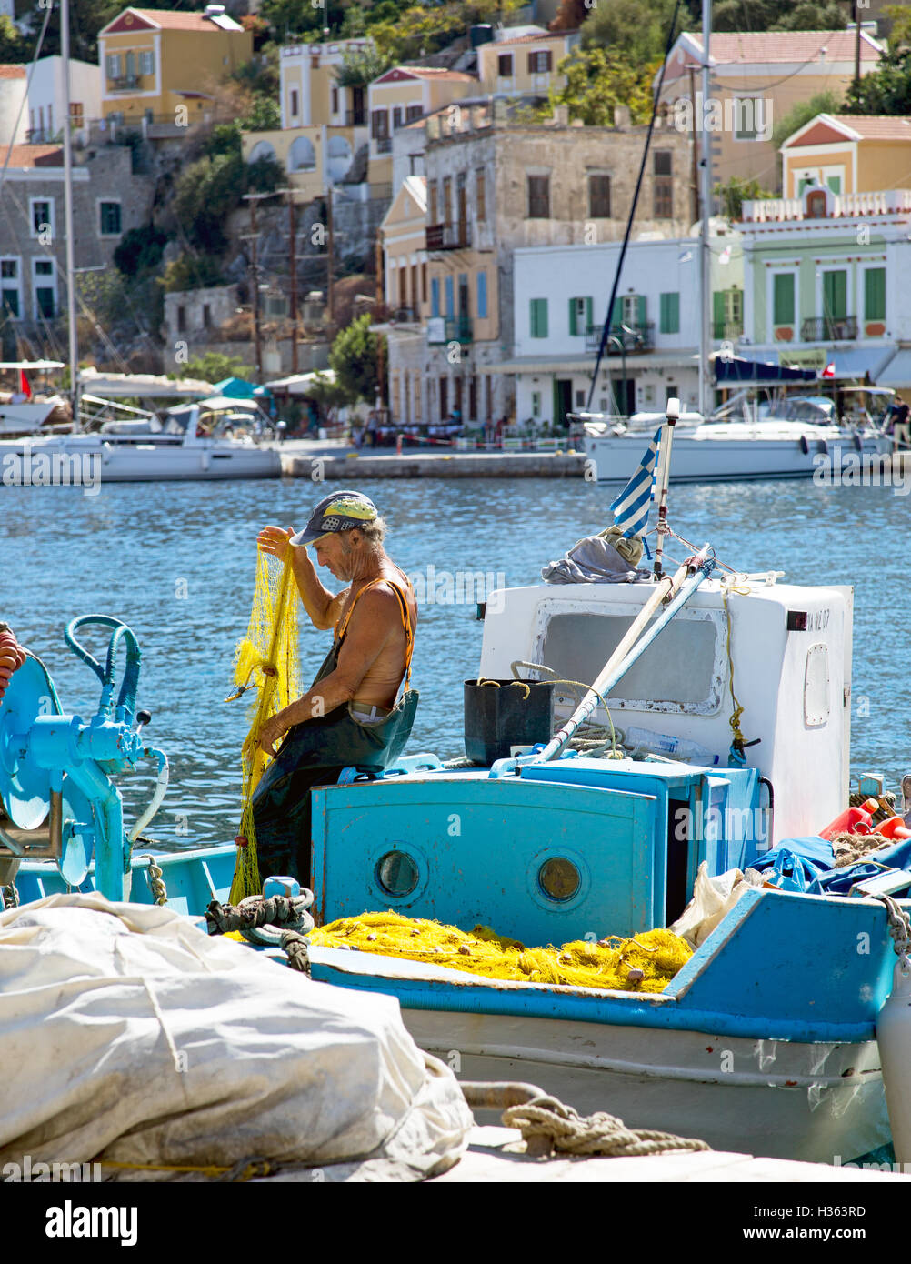 Fischer mit seinem Boot und Netze Symi Stadt Griechenland Stockfoto