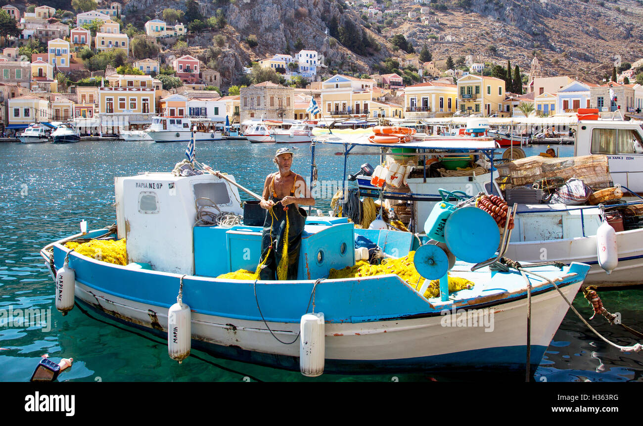 Fischer mit seinem Boot und Netze Symi Stadt Griechenland Stockfoto