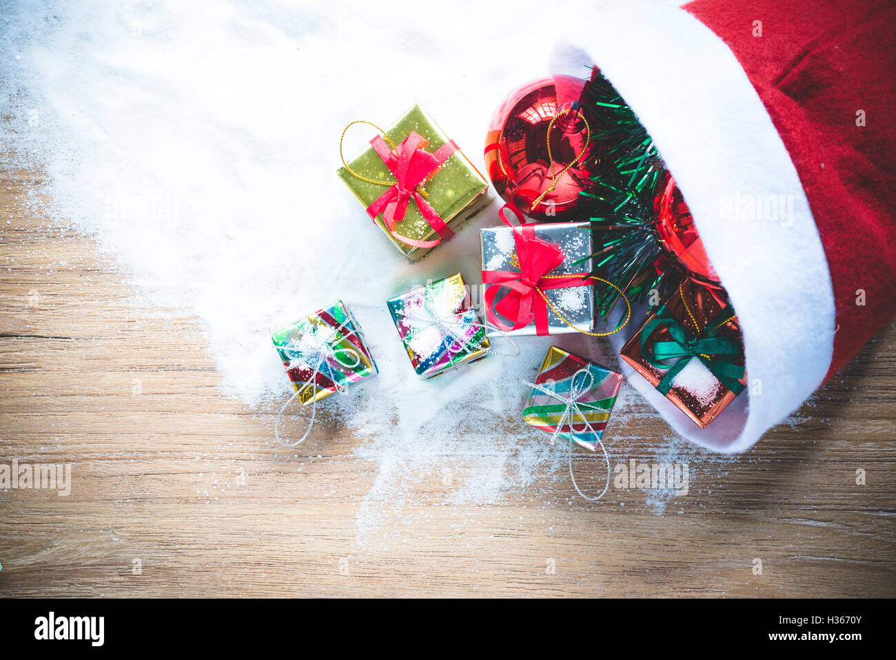 Merry x-mas Weihnachten Dekorationen Hintergründe, rote Weihnachtskugeln und Geschenk-Box an den roten Weihnachtsmann Mütze Dekorationen auf Schnee Stockfoto