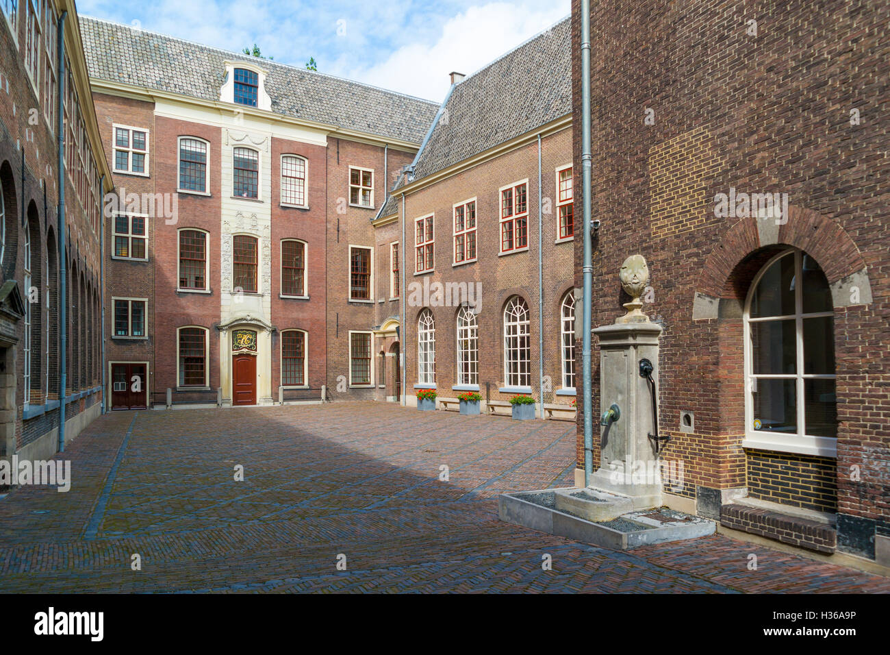 Innenhof des ehemaligen Waisenhauses mit Wasserpumpe in der alten Stadt von Leiden, Südholland, Niederlande Stockfoto