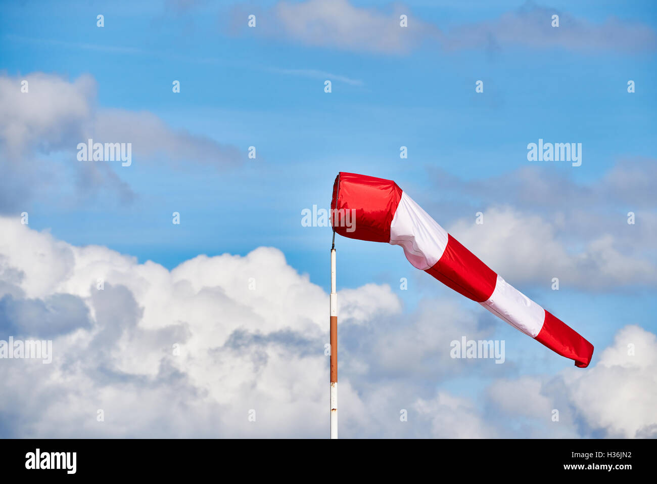 Rote und weiße Metoreology Windstock an einem Flughafen mit blauem Himmel - gemischte Wolken. Stockfoto