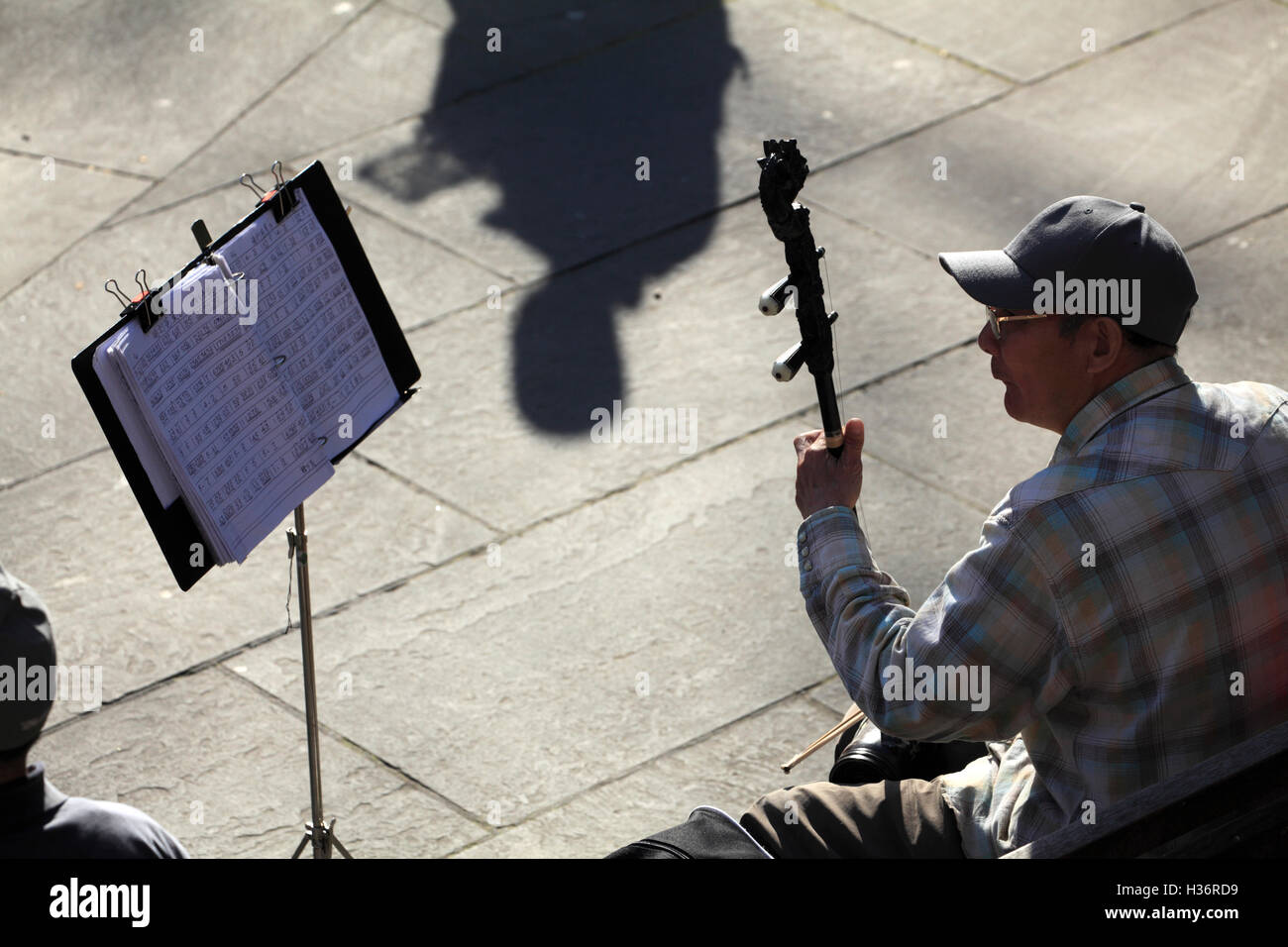 Ein Mann spielt Erhu eine traditionelle chinesische zweisaitiges gebeugt Musikinstrument in Columbus Park.Chinatown.New York City.USA Stockfoto