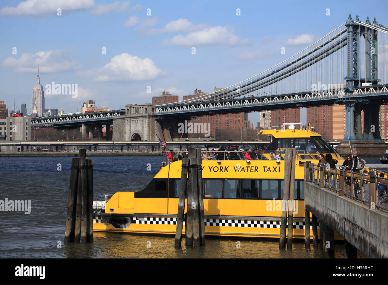 Ein New York Water Taxi Fulton Ferry Landing mit Manhattan Bridge & Empire State Building im Hintergrund. New York City.USA Stockfoto