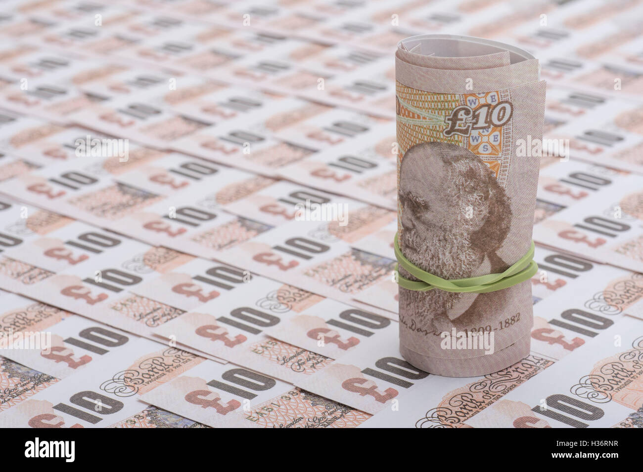 Aufgerollt altes Design £ 10 Banknoten - als visuelle Metapher für das Konzept der britischen Währung, Löhne, Einkommen, Wirtschaft und Inflation. Stockfoto