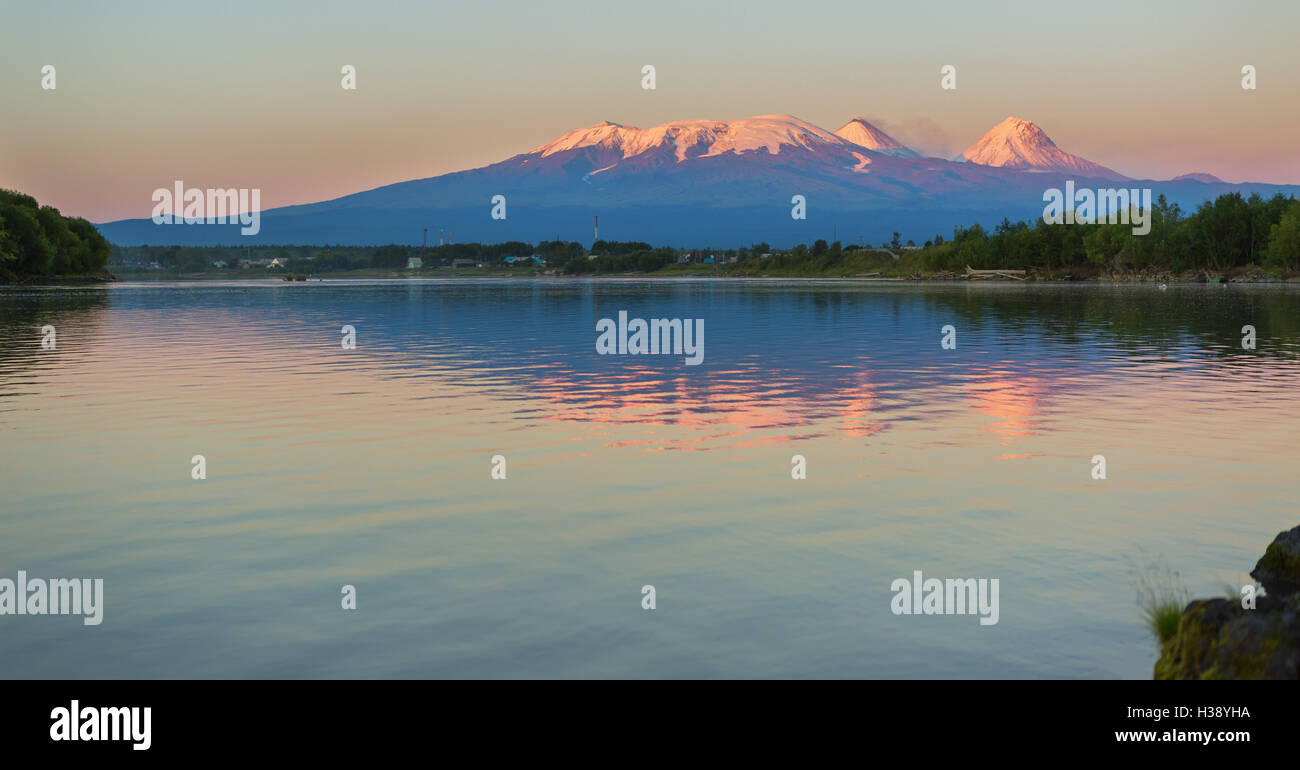 Sonnenuntergang Kluchevskaya Lichtkonzern der Vulkane mit Spiegelbild im Fluss Kamtschatka. Stockfoto