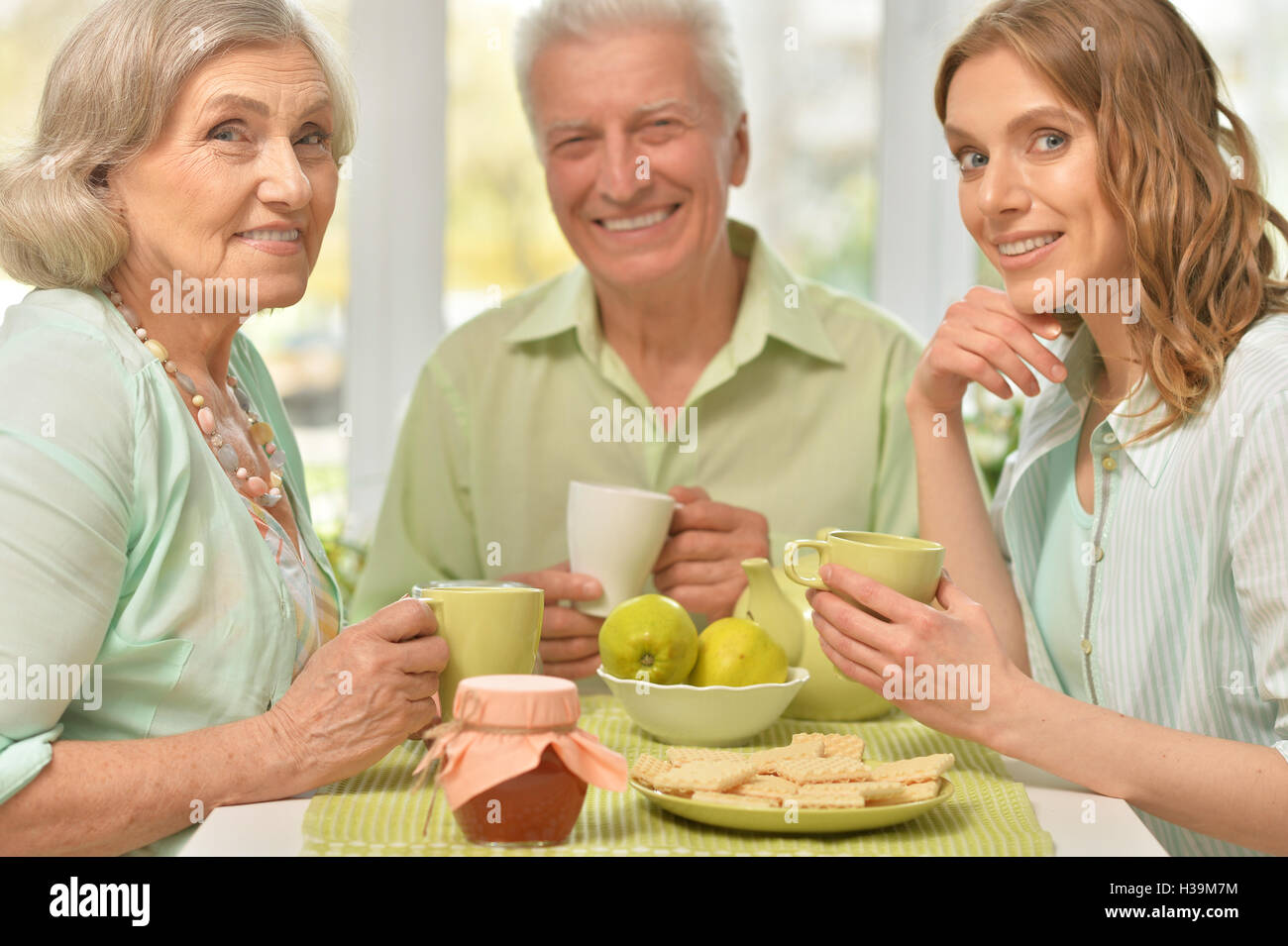 Tochter mit älteren Eltern Tee trinken Stockfoto