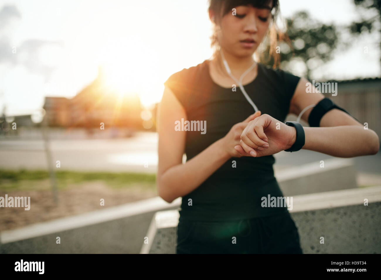 Nahaufnahme einer jungen Joggerin, die zum Laufen bereit ist und Smartwatch ansieht. Fitness-Frau überprüft ihre Leistung. Stockfoto