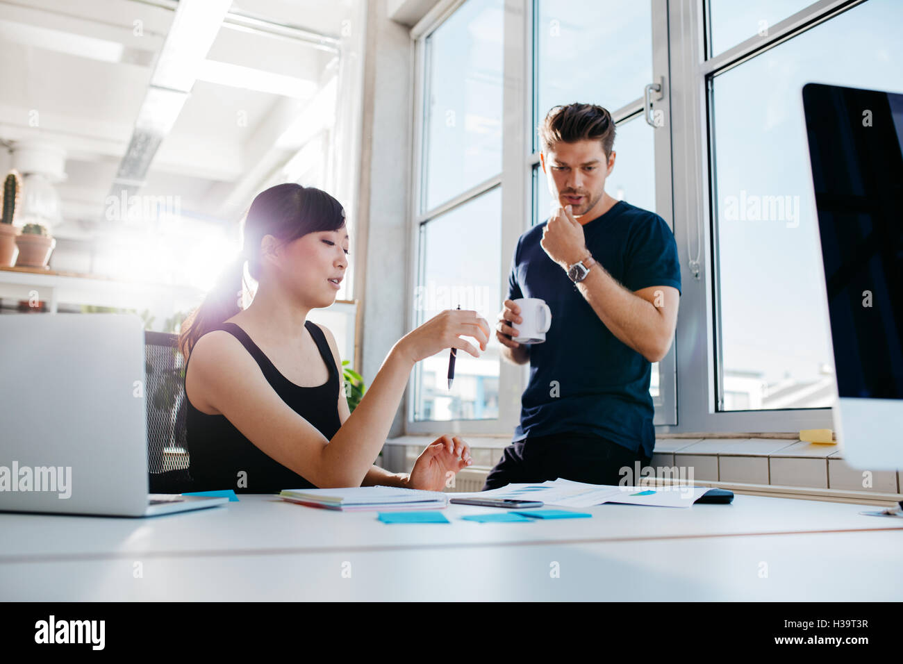 Aufnahme von zwei jungen Kollegen arbeiten in modernen Büros. Mitarbeiter Business Ideen zu diskutieren. Stockfoto