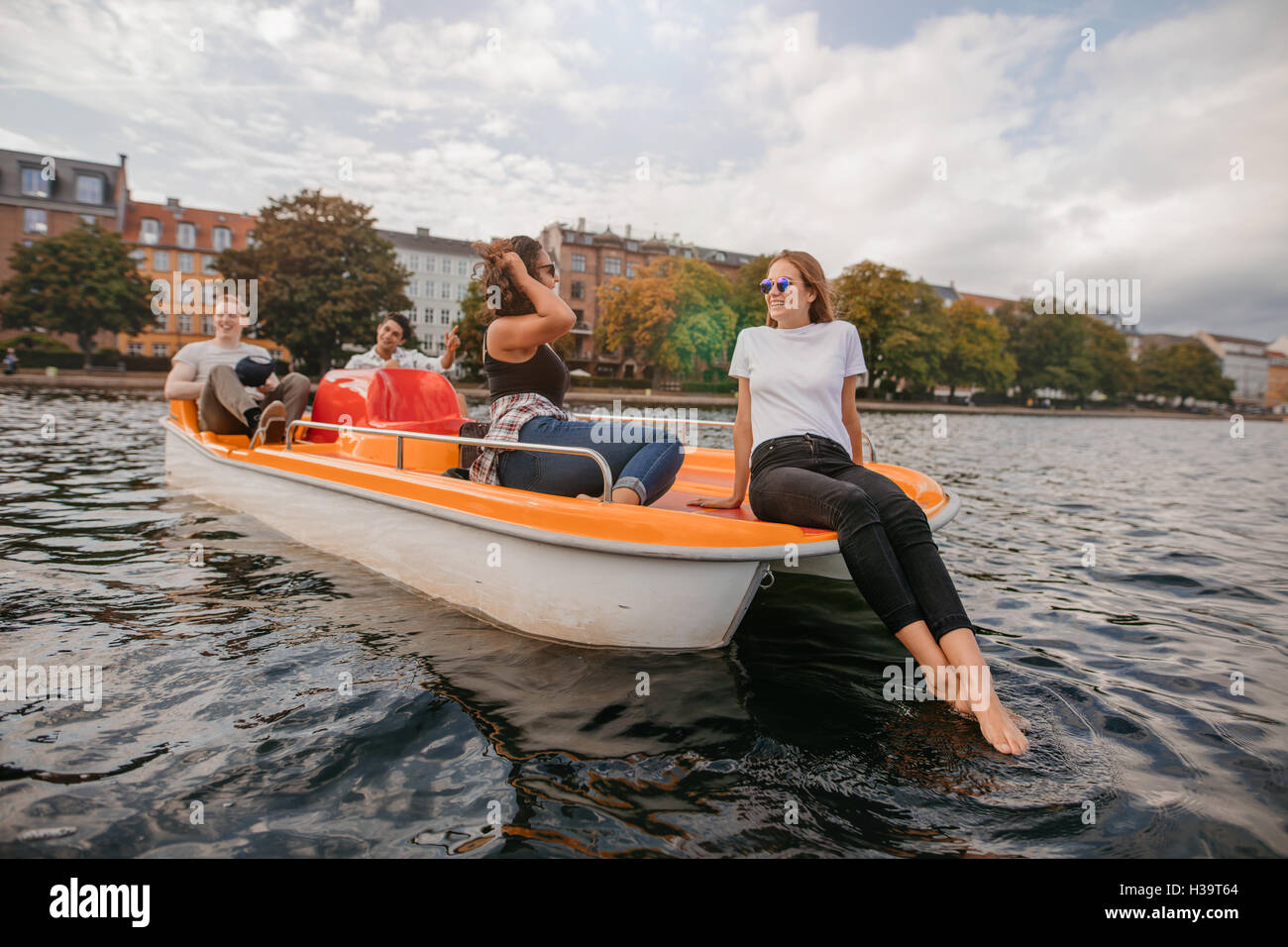 Im Freien Schuss von Teenager Freunden entspannende Pedal Boot in See. Junge Männer und Frauen, Bootfahren und Urlaub zu genießen. Stockfoto